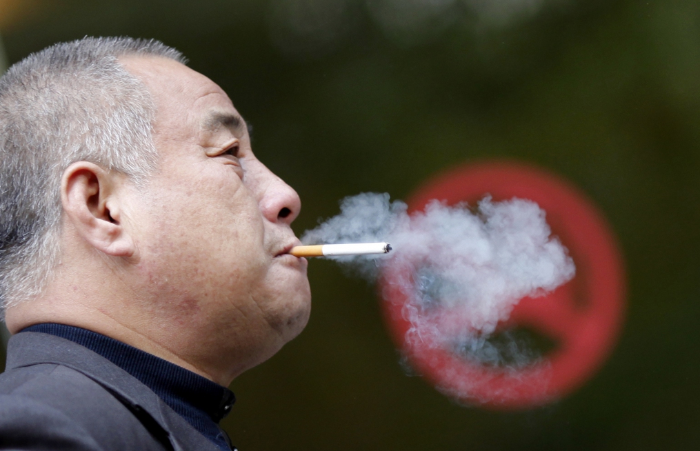 A man smokes next to a