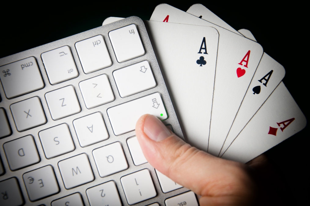 Poker On-line. Keyboard and four aces in hand.