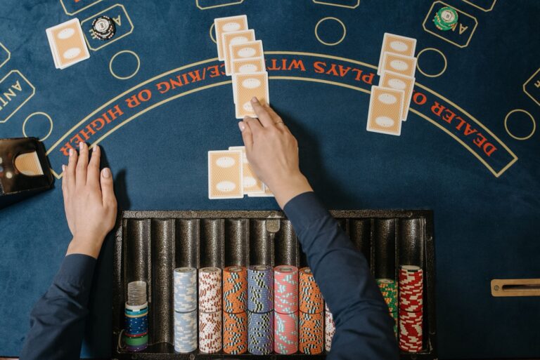 Casino dealer dealing cards at a table game with stacks of chips