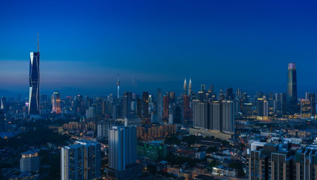 Discover the vibrant Kuala Lumpur skyline featuring iconic landmarks in the evening glow.